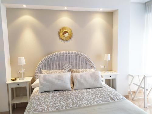 艾因薩的住宿－Las Tres Sorores，一间卧室配有白色的床、两张桌子和镜子