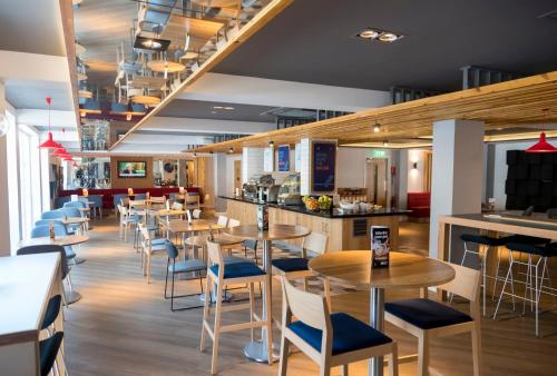 a restaurant with tables and chairs and a bar at Holiday Inn Express Aberdeen City Centre by IHG in Aberdeen