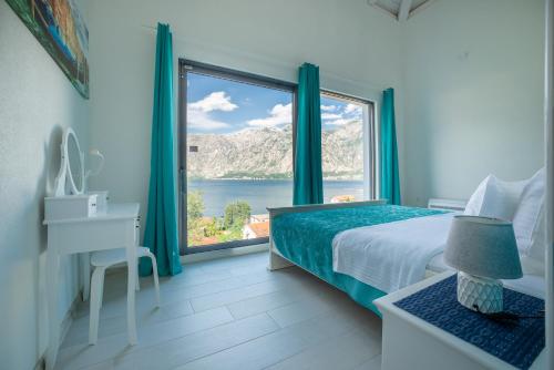 a bedroom with a bed and a desk and a window at StOliva RESIDENCE with infinity pool in Kotor