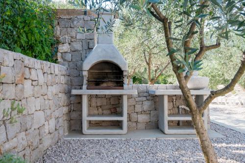 a stone wall with a pizza oven in a yard at StOliva RESIDENCE with infinity pool in Kotor