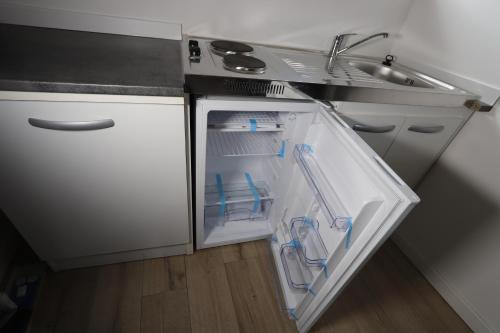 - un réfrigérateur ouvert dans une cuisine à côté d'un évier dans l'établissement Homeday, à Haguenau