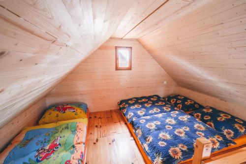a bedroom with two beds in a wooden attic at chaticky.basta in Čakov