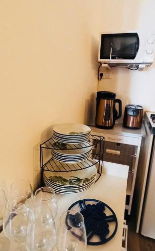 a pile of plates and glasses on a kitchen counter at Résidence LE11B in Uzerche