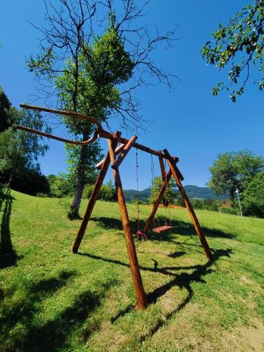 an old swing set in a grassy field at Brunarica Biopark -Log house Biopark in Grosuplje