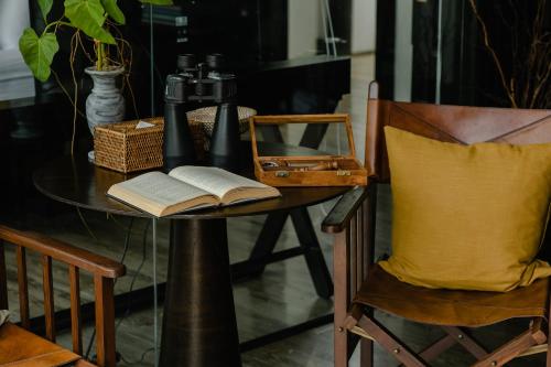 a table with an open book on a table with a chair at Kachonghills Tented Resort Trang in Trang