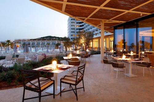 a restaurant with tables and chairs on a patio at TRS Ibiza Hotel - Adults Only in San Antonio