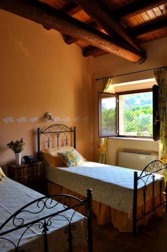 a bedroom with two beds and a window at Tenuta Bellaprima CALTAGIRONE in Niscemi