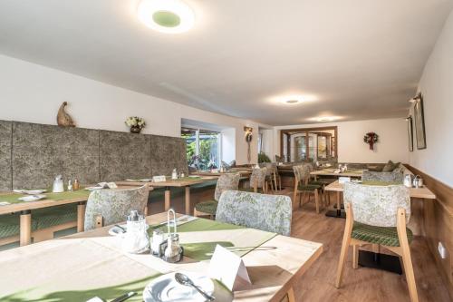 a dining room with wooden tables and chairs at Hotel-Pension Falkensteiner in Sankt Gilgen