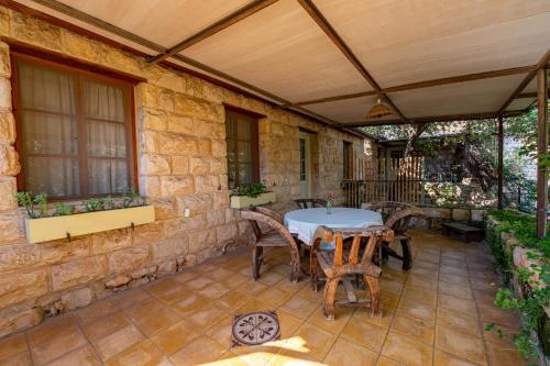 an outdoor patio with a table and chairs at Hemdatya Stone Suites In The Galilee in Ilaniya