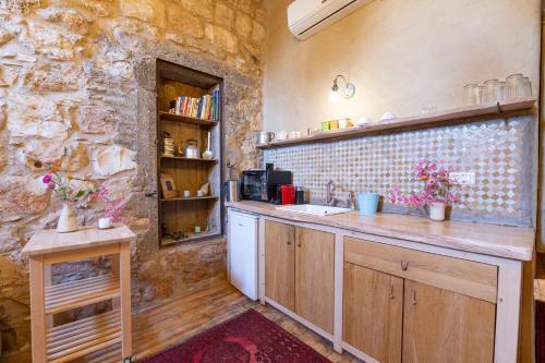 a kitchen with a counter and a stone wall at Hemdatya Stone Suites In The Galilee in Ilaniya