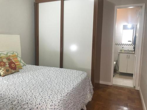 1 dormitorio con cama y baño con espejo. en Incrivel quarto sala Ipanema em frente ao metro - Jangadeiros duas quadras da praia, en Río de Janeiro