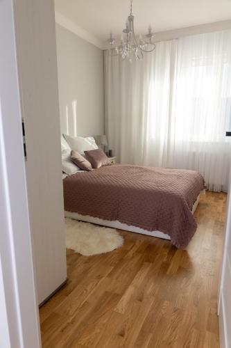 a bedroom with a bed and a chandelier at Apartamenty Termalne Dobry Klimat in Uniejow