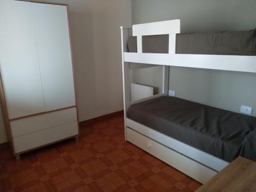 a bedroom with a bunk bed and a cabinet at CASA MUY COMODA A METROS DEL SANTUARIO Y ECOPARQUE in San Nicolás de los Arroyos