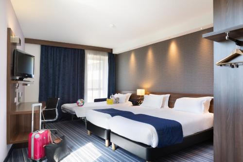a hotel room with two beds and a television at Holiday Inn Express Toulon - Est by IHG in Toulon