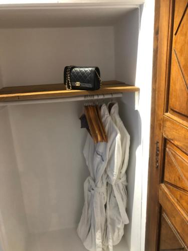 a closet with a shelf and a purse on it at Les Horizons - SPA-JACUZZI - MASSAGE- SAUNA - 4 SAISONS - Piscine chauffée Toute l'année - 800m centre ville Nyons in Nyons