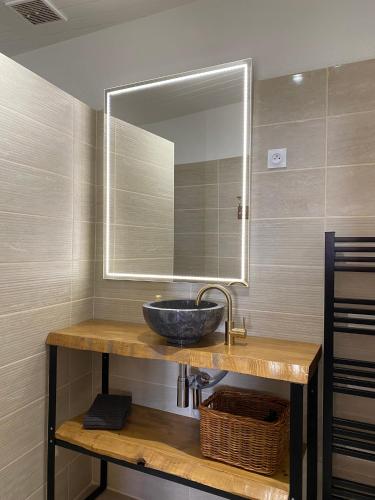 une salle de bain avec un lavabo et un miroir dans l'établissement Gîtes de la Roullière, à Le Longeron