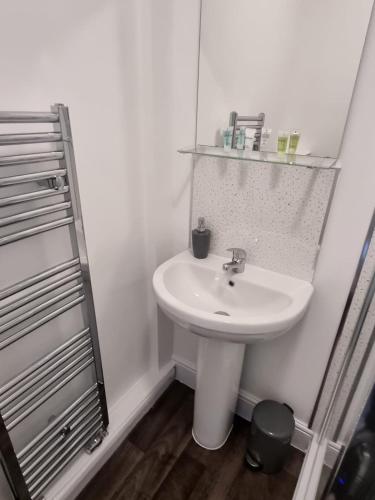 a white bathroom with a sink and a mirror at Grey Stone Studio Apartments in Halifax
