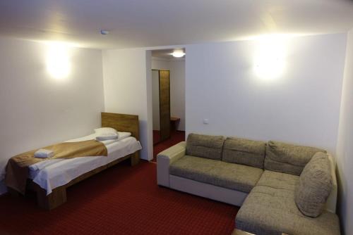 a hotel room with a couch and a bed at Cabana Fulg De Nea Predeal in Predeal