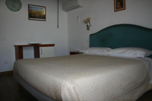 a bedroom with a large bed with a green headboard at A casa di Giò in Loreto