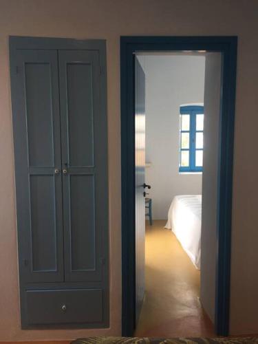 a room with a door and a bedroom with a bed at Traumhaus Nisyros in Páloi