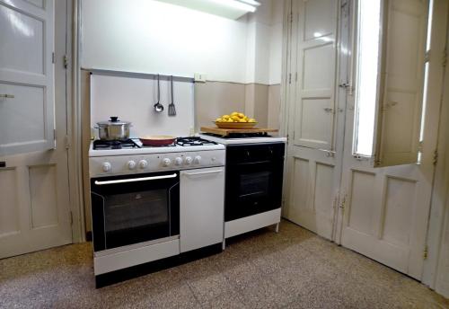 a kitchen with a stove with a bowl of fruit on it at Casa Vacanze Borgata del Sorbo in Acireale