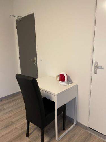 a white table with a black chair and a red telephone at Hotel B&B Sint-Maria NEXT DOOR in Valkenburg