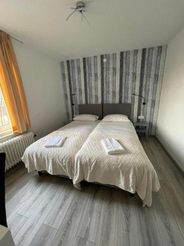 a bedroom with a large bed with a wooden floor at Hotel B&B Sint-Maria NEXT DOOR in Valkenburg