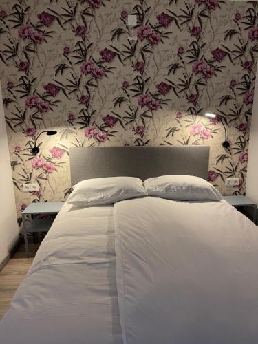 a bedroom with a bed with a floral wallpaper at Hotel B&B Sint-Maria NEXT DOOR in Valkenburg