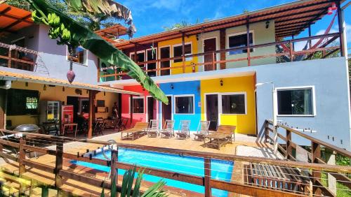 a house with a swimming pool in front of it at Farofa Loca Hostel in Morro de São Paulo