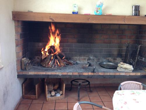 a brick fireplace with a fire in it at Ciudad Encantada Tio Daniel in Valdecabras