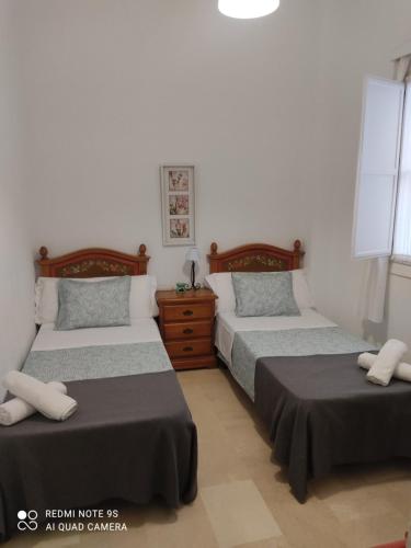 um quarto com 2 camas e uma cómoda em PISO 2 HABITACIONES SEVILLA CENTRO WIFI em Sevilha