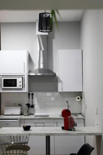 a kitchen with white cabinets and a counter top at Apartamentos Las trece llaves Jacuzzi bajo reserva in Merida