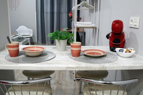 a table with plates and bowls on top of it at Apartamentos Las trece llaves Jacuzzi bajo reserva in Mérida