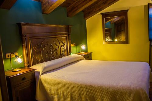 a bedroom with a large bed and a mirror at EL NIDO DE OLVIDO in Meiro