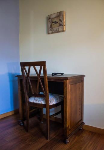 a wooden desk with a chair next to a wall at EL NIDO DE OLVIDO in Meiro