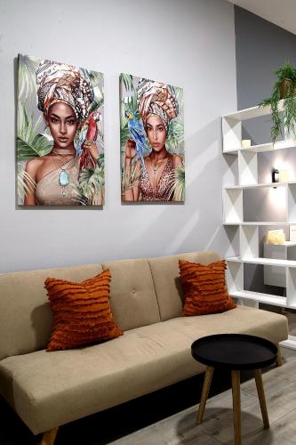 four paintings of a woman on a wall at Apartamentos Las trece llaves Jacuzzi bajo reserva in Merida