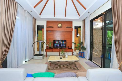 Una sala de estar con un sofá blanco y una mesa. en 3bedroom pool villa only 250m to the Rawai beach F10, en Phuket