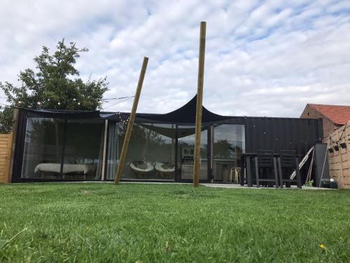 a black tent in the middle of a yard at Tussen de paarden @ De Hoeveschuur in Riemst
