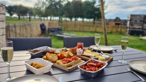 un tavolo con vassoio di cibo e bicchieri di vino di Tussen de paarden @ De Hoeveschuur a Riemst