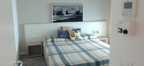 een slaapkamer met een bed en een foto aan de muur bij Soggiorno Aurora in Caorle