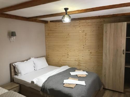 サチェレにあるPensiunea Haiduc Sacele Brasovの木製の壁のベッドルーム1室(ベッド1台付)