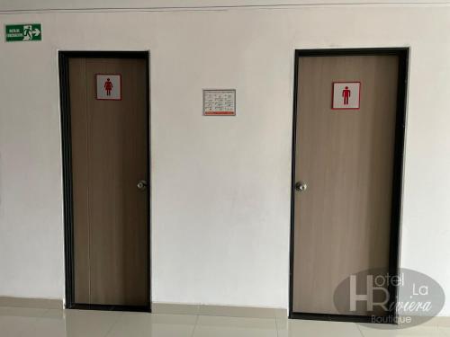 two brown doors in a room with signs on them at Hotel Boutique La Riviera in Rivera