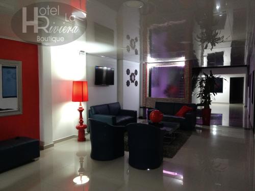 a living room with couches and a table and chairs at Hotel Boutique La Riviera in Rivera