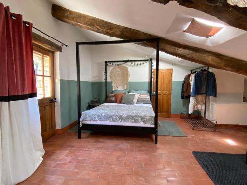 a bedroom with a canopy bed in a room at La Tour des Baronnies à la Porte de l eau in Saint-Auban-sur-lʼOuvèze