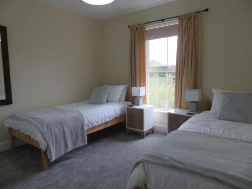 a bedroom with two beds and a window at Marr Cottage in Thornhill