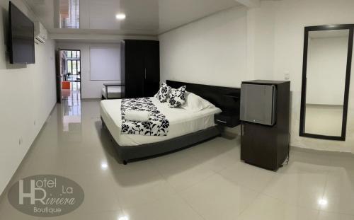 a bedroom with a bed and a tv in it at Hotel Boutique La Riviera in Rivera