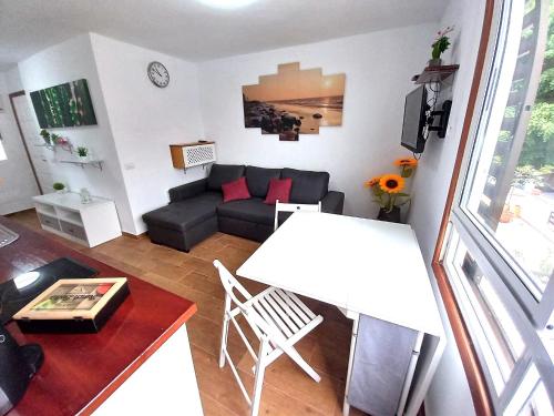uma sala de estar com um sofá e uma mesa em Jema Apartamento Playa San Marcos by HRTenerife Net em Icod de los Vinos