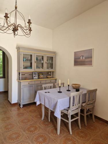 une salle à manger avec une table, des chaises et un lustre dans l'établissement Casa Aresula, à San Teodoro