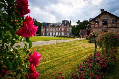 a large brick building with pink flowers in front of it at Gîte de Montfranc in Pierrefitte-sur-Sauldre