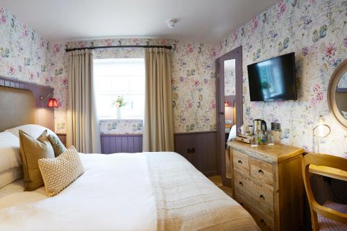 a bedroom with a bed and a tv on the wall at The Grainary Boutique B&B in Scarborough